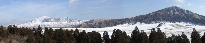 雪景色の草千里浜と阿蘇中岳、阿蘇烏帽子岳の写真