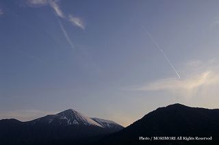 冠雪した高千穂峰と鹿児島空港へ向かう航空機の飛行機雲